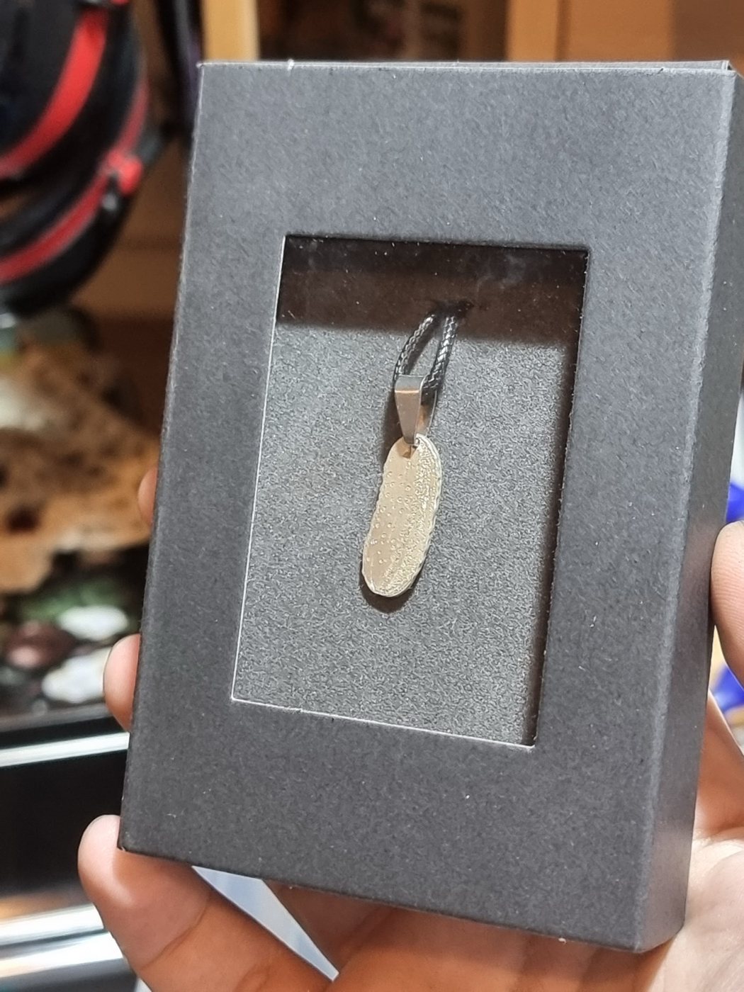 A small pendant with a detailed laser-etched scene