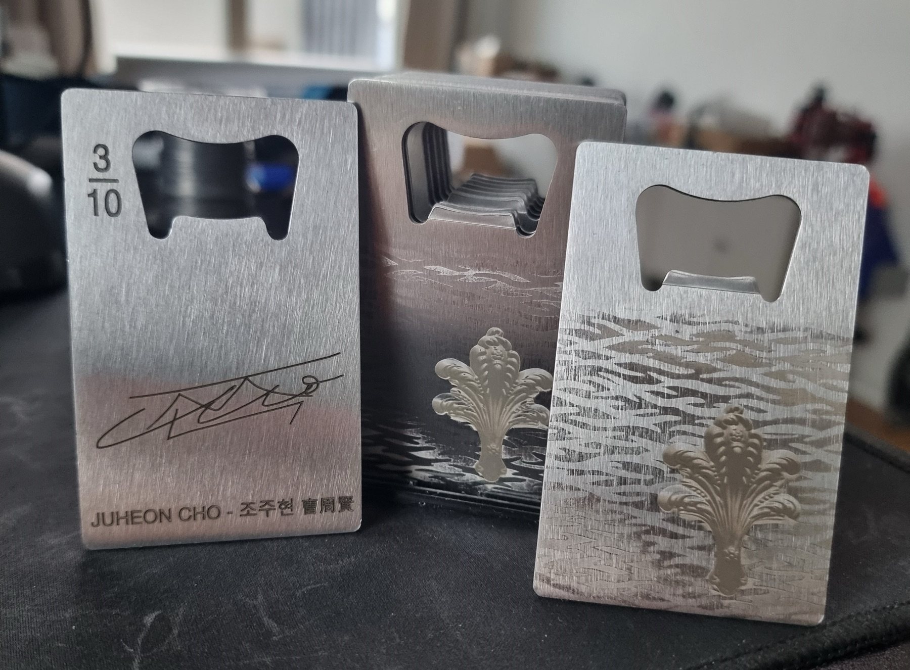 A set of custom engraved metal bottle opener cards